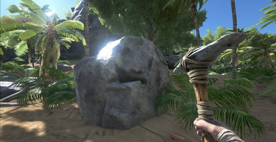 Screenshot of ARK: Survival Evolved Mobile. Hand with a pickaxe in front of a big stone